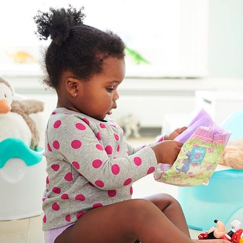 Girl in Pull-Ups® training pants practicing potty training.